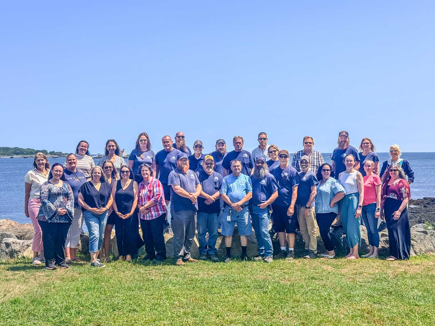 Group picture of the staff in front of the water
