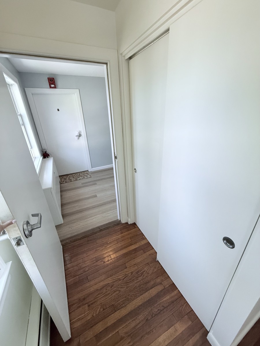 Coat closet and apartment exit into hallway